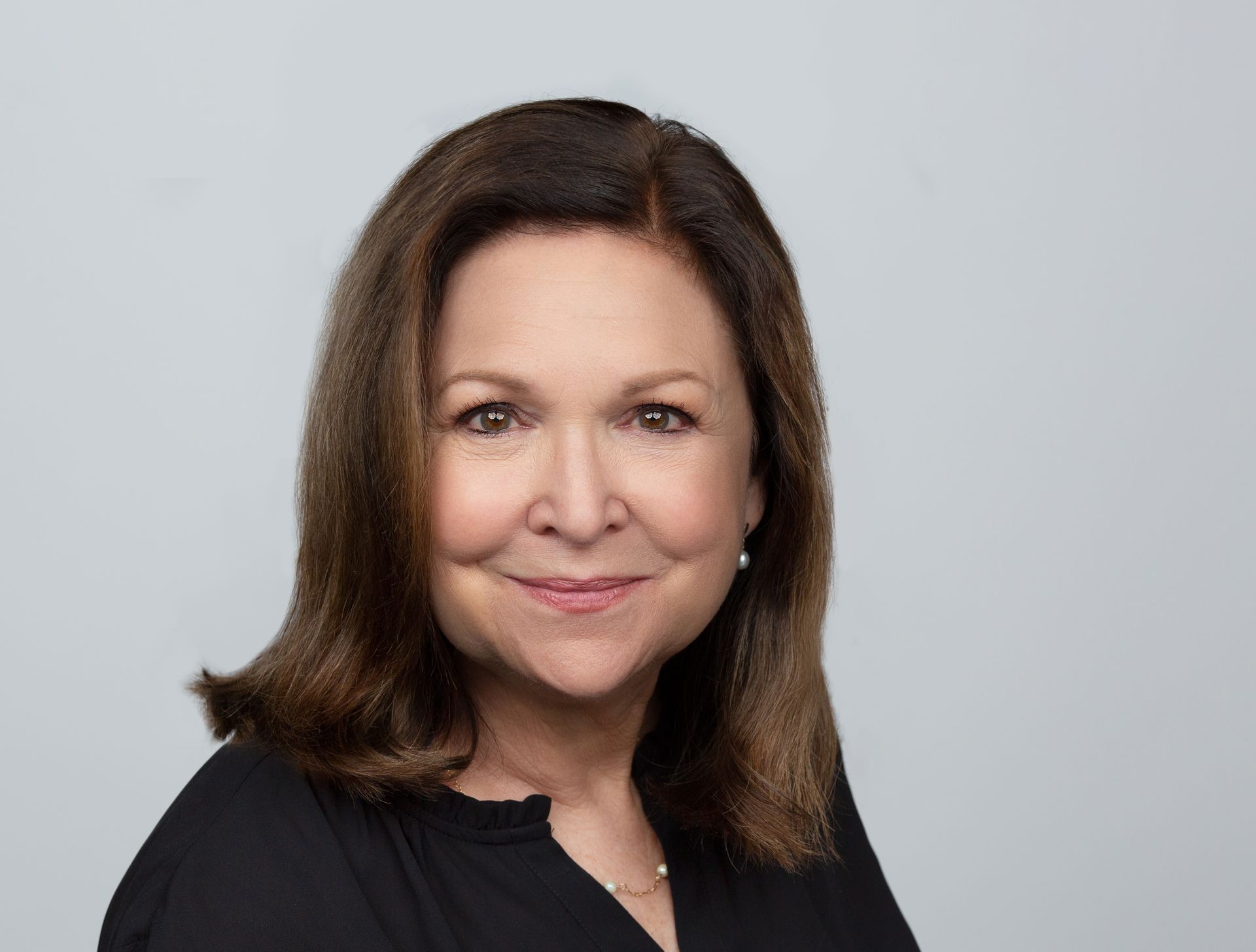 A woman in a black shirt is smiling for the camera.