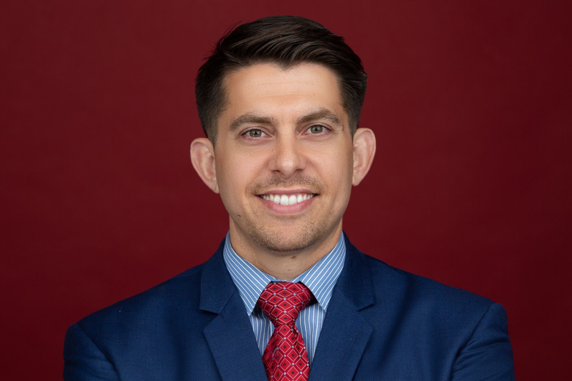 A man in a suit and tie is smiling for the camera.