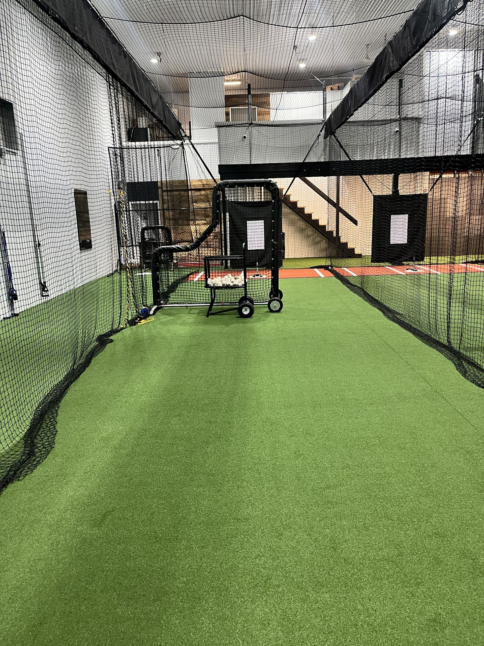 Softball hitting practice inside The Hitting House indoor batting cages