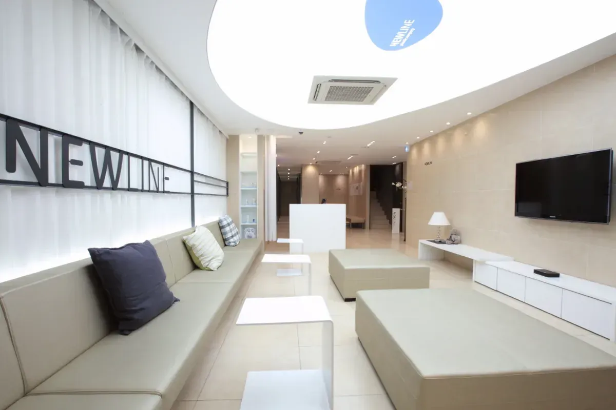 Modern spa treatment room with two massage beds, soft lighting, and green walls