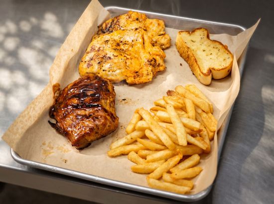 Takeout container with grilled chicken, fries, and toasted bread wrapped in foil