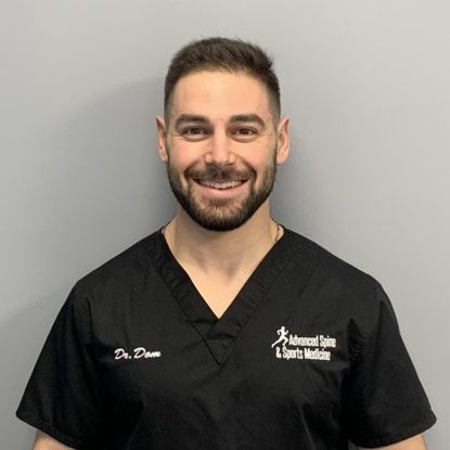 Man in black scrubs smiles. Text reads 