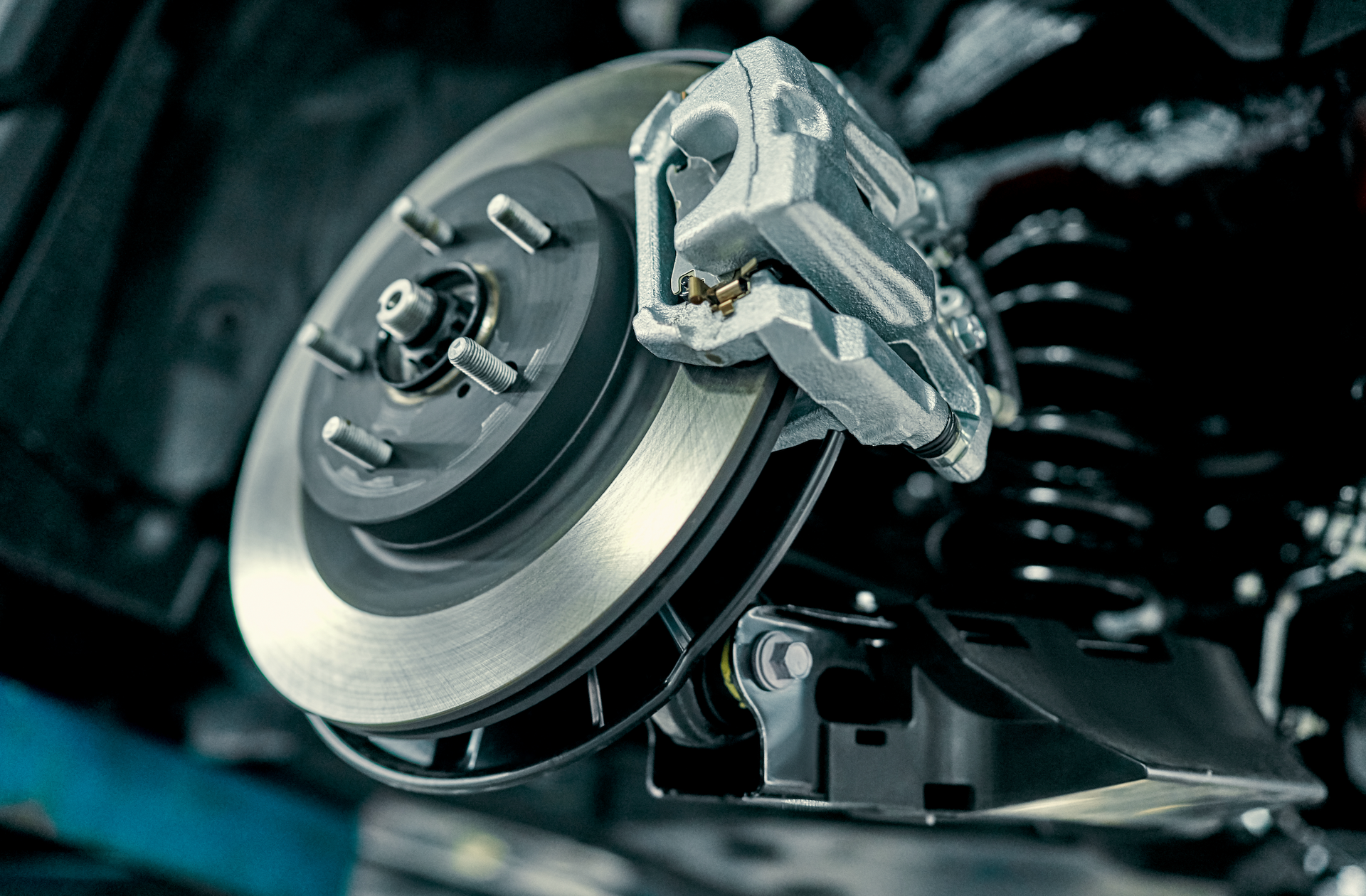 A close up of a brake disc and brake caliper on a car.