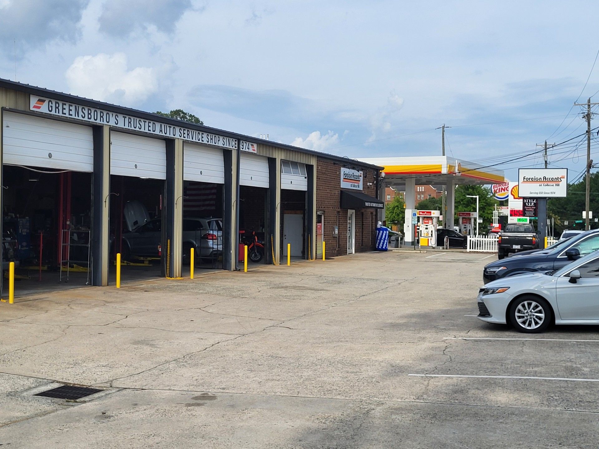 Auto repair shop with several cars lifted on hydraulic hoists inside a bright service garage