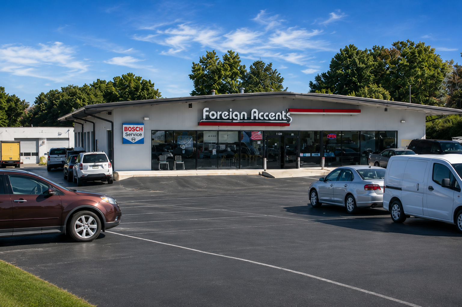 Auto repair shop with several cars lifted on hydraulic hoists inside a bright service garage