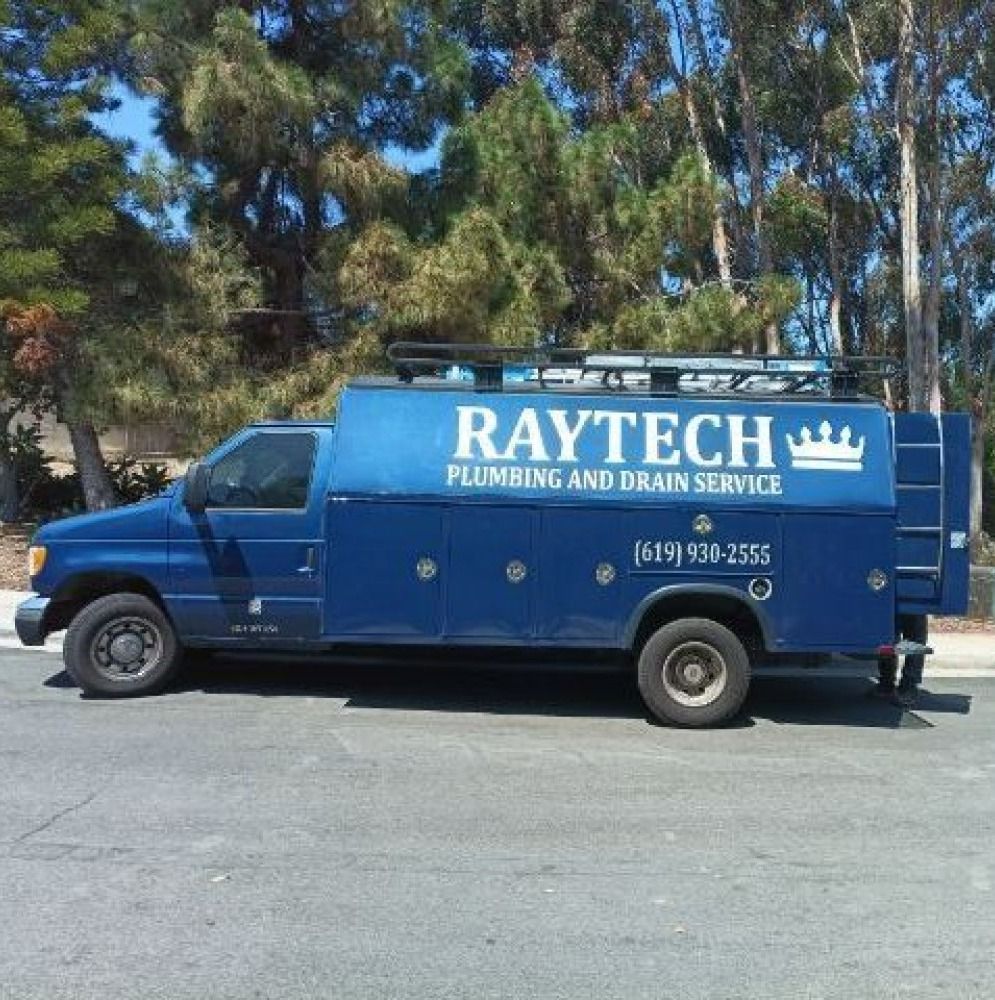 Blue Raytech plumbing and drain service truck parked on asphalt.