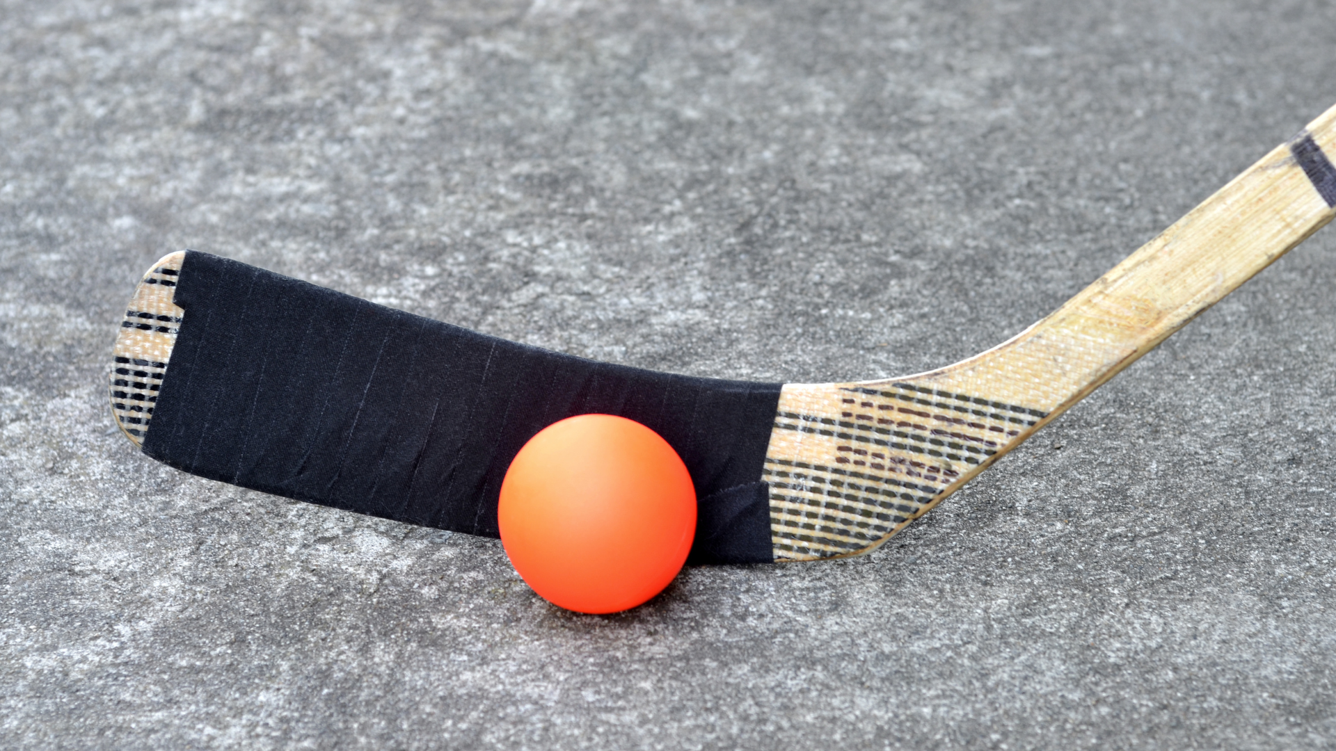 A hockey stick with an orange ball on it