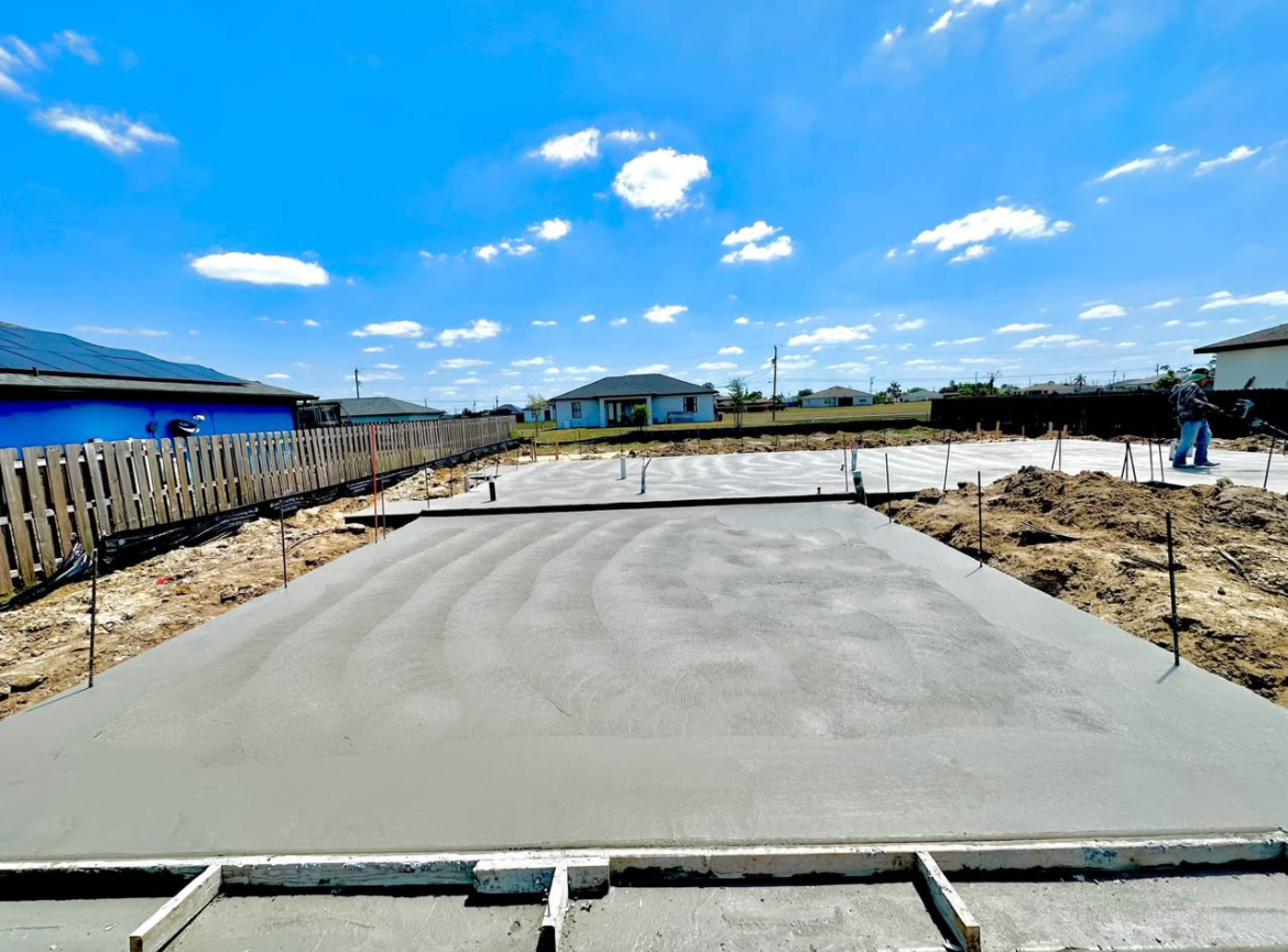 Fresh concrete slab at a construction site under a bright blue sky