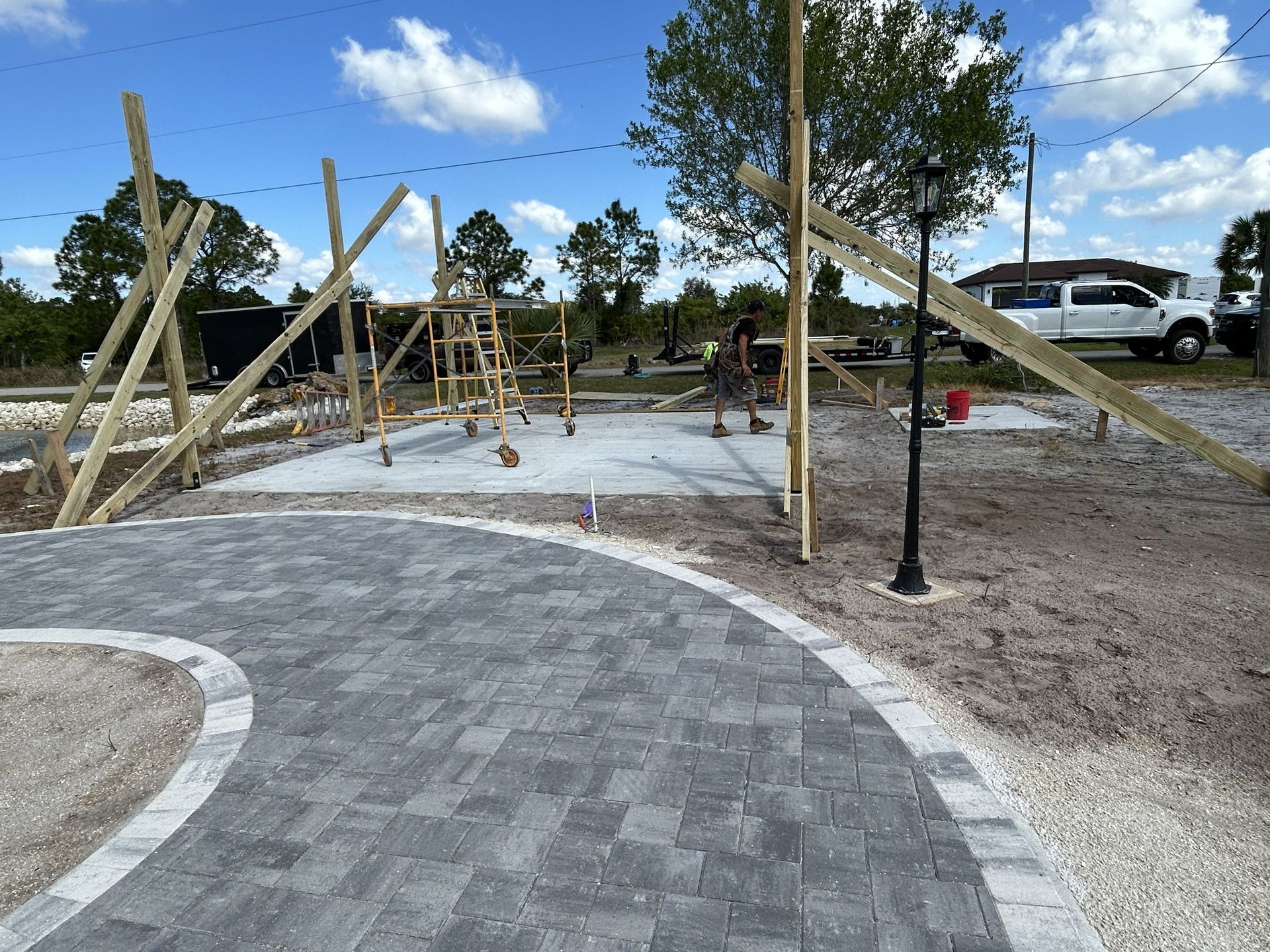 Curved stone walkway beside playground climbing structures under a blue sky