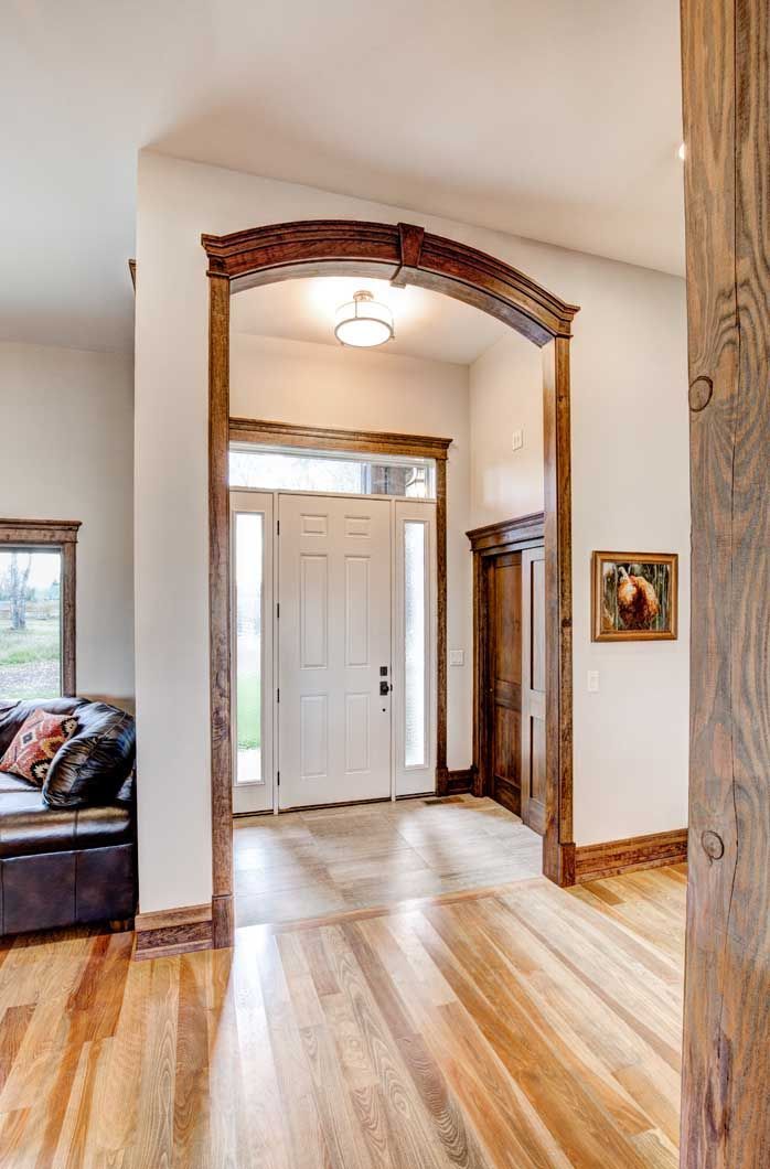 A hallway in a house with hardwood floors and a white door.