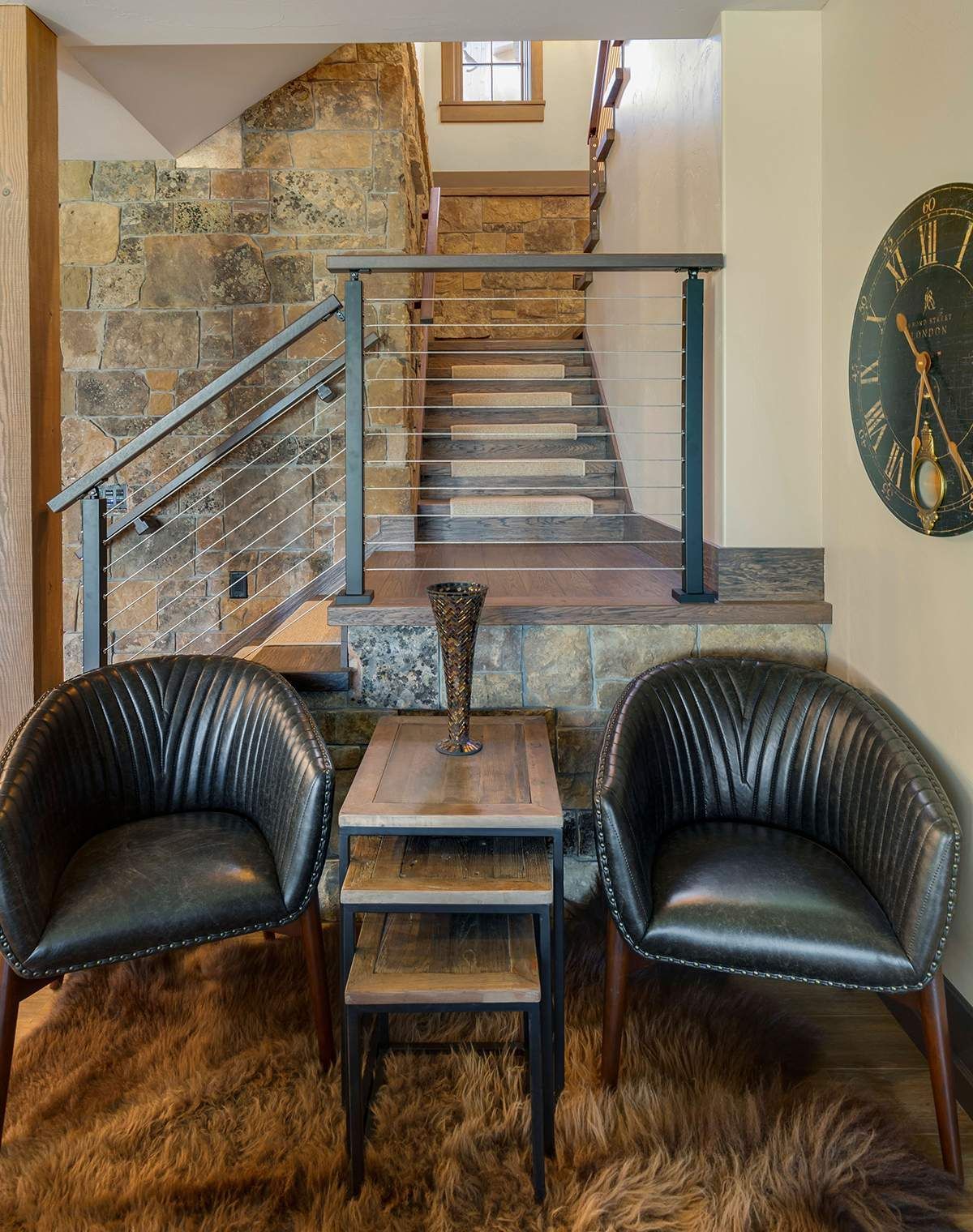 A living room with two chairs and a clock on the wall