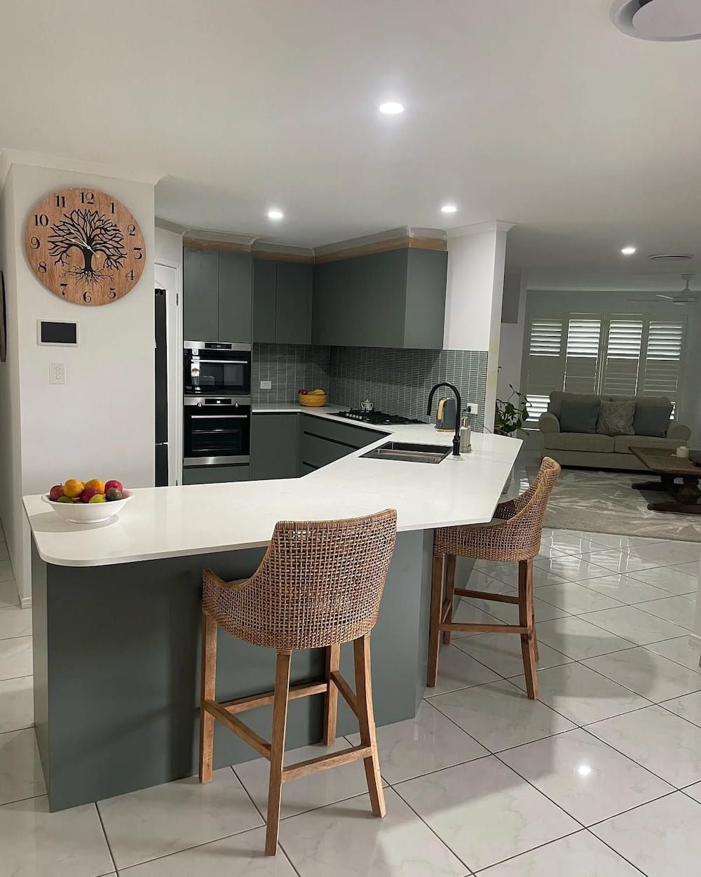 A Kitchen With Two Wicker Chairs And A Clock On The Wall — D & L Custom Cabinets  In Byron Bay, NSW 