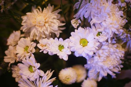 A basket filled with flowers is sitting on a wooden table.