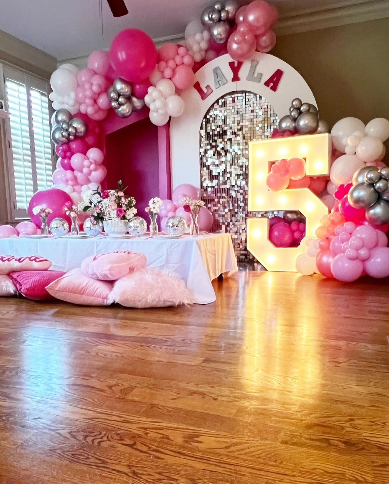 Pink and silver balloon arch with a white, light-up 