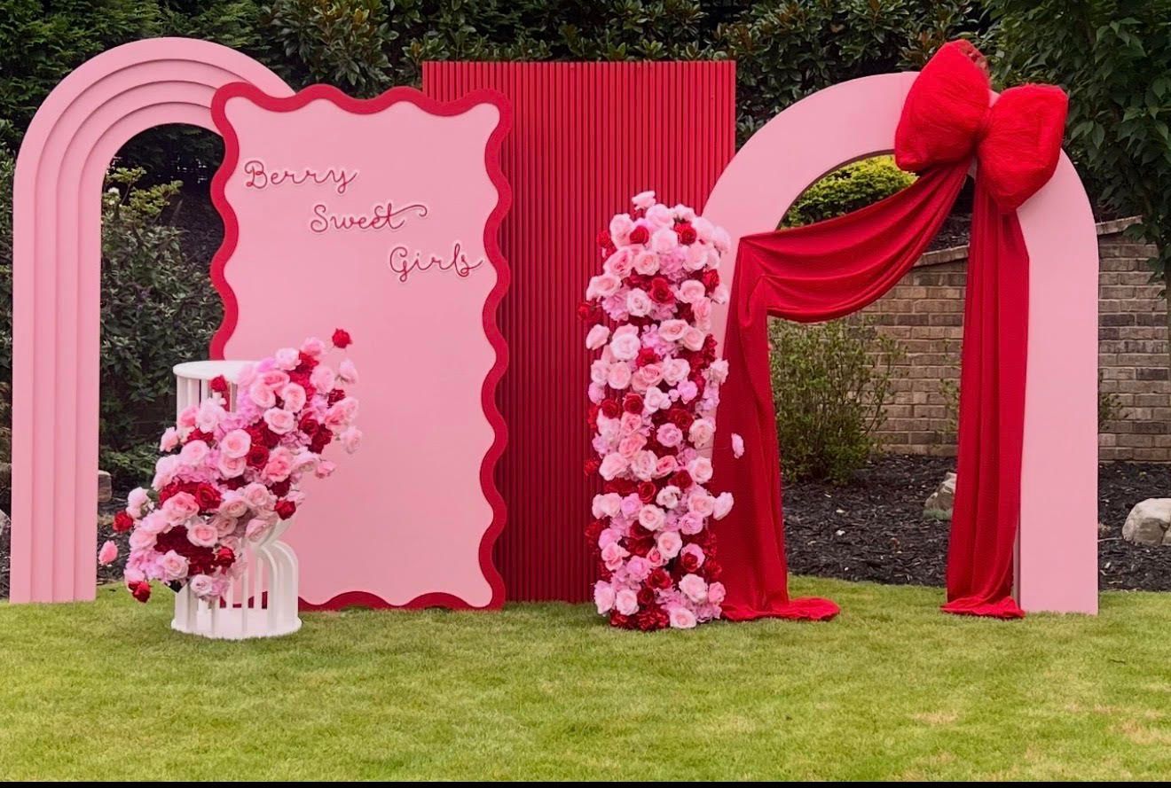 Pink and red decorative backdrop on green grass for a