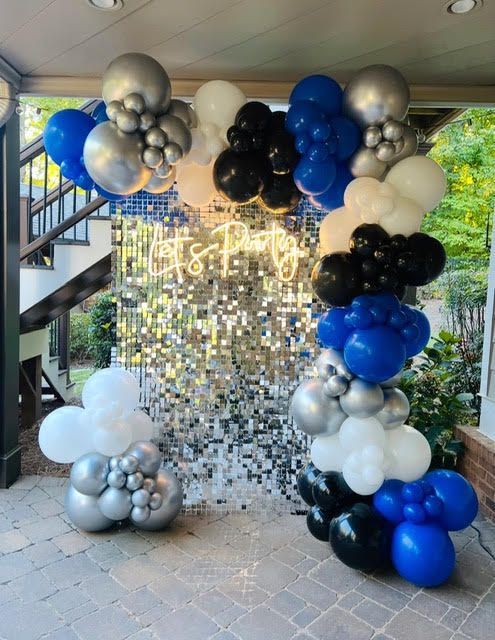 Balloons archway with silver, white, blue and black balloons.