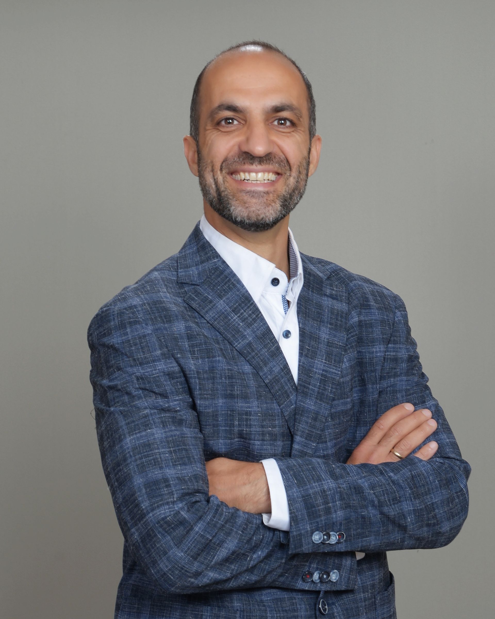 A man with a beard wearing a blue suit and red tie