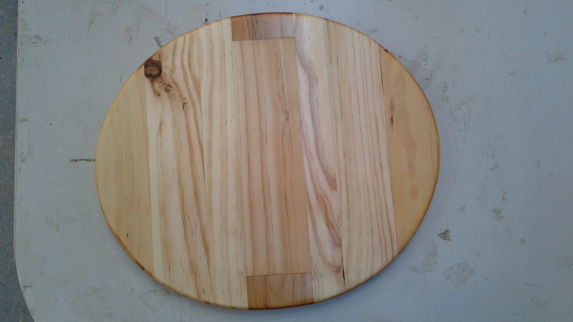Oval wooden cutting board on a gray surface