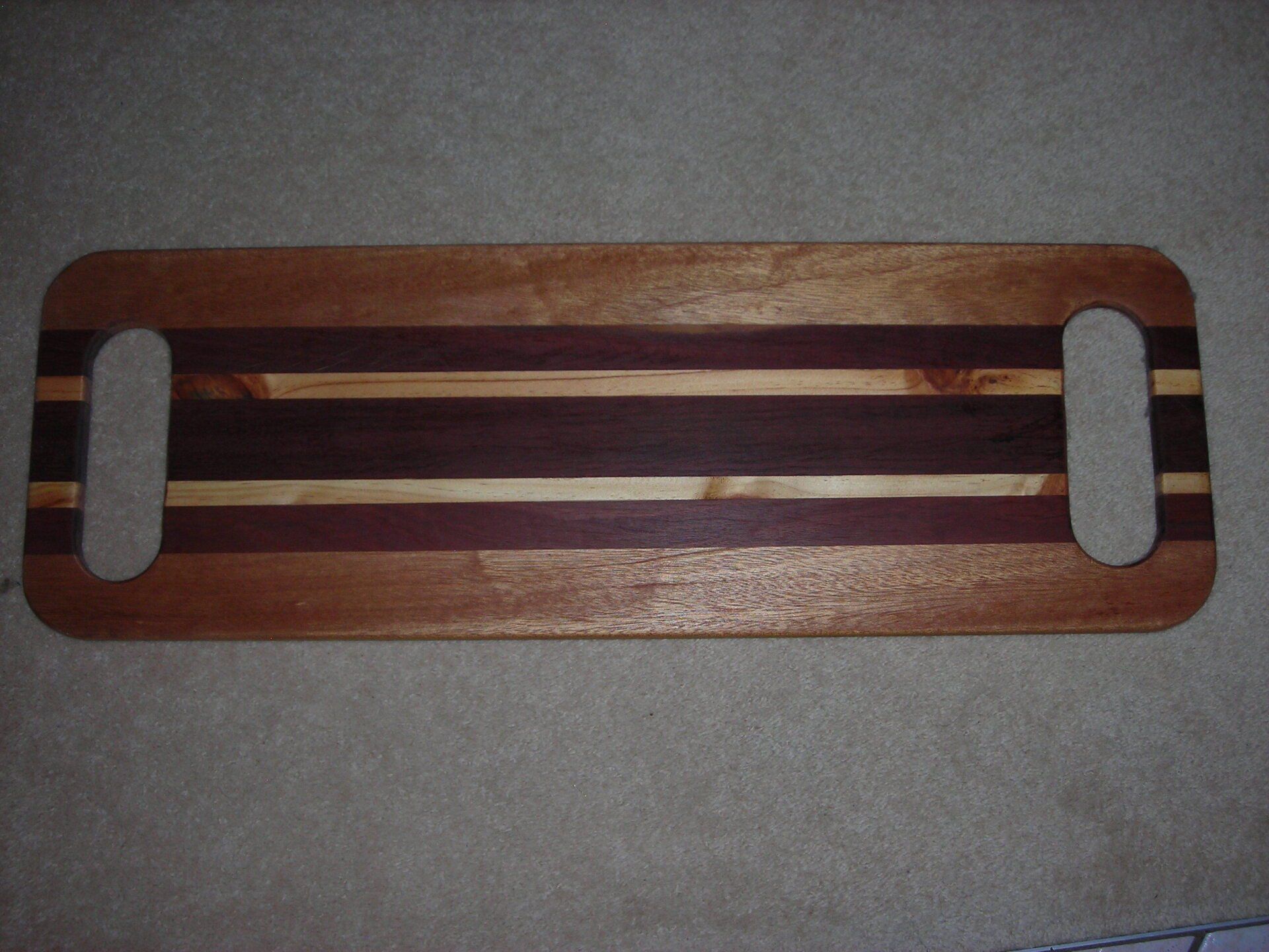 Rectangular wooden serving tray with two oval cutout handles and gray inlays