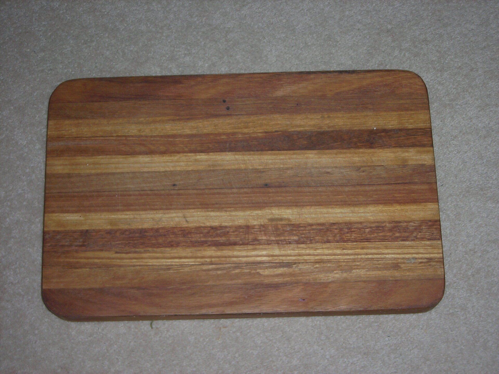 Wooden cutting board with rounded corners on a gray surface