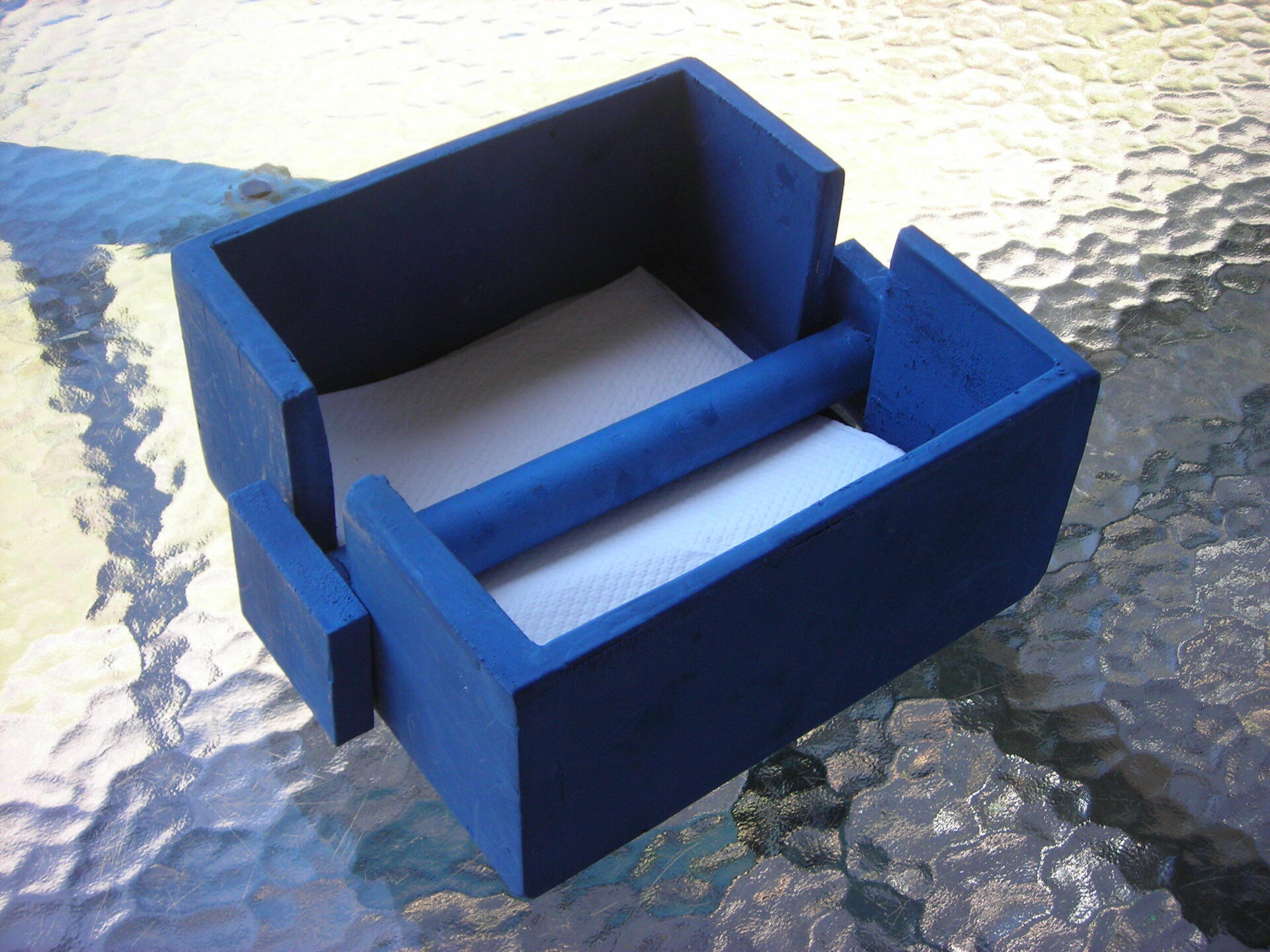 Blue cardboard box with two compartments and a divider, resting on a glass tabletop.