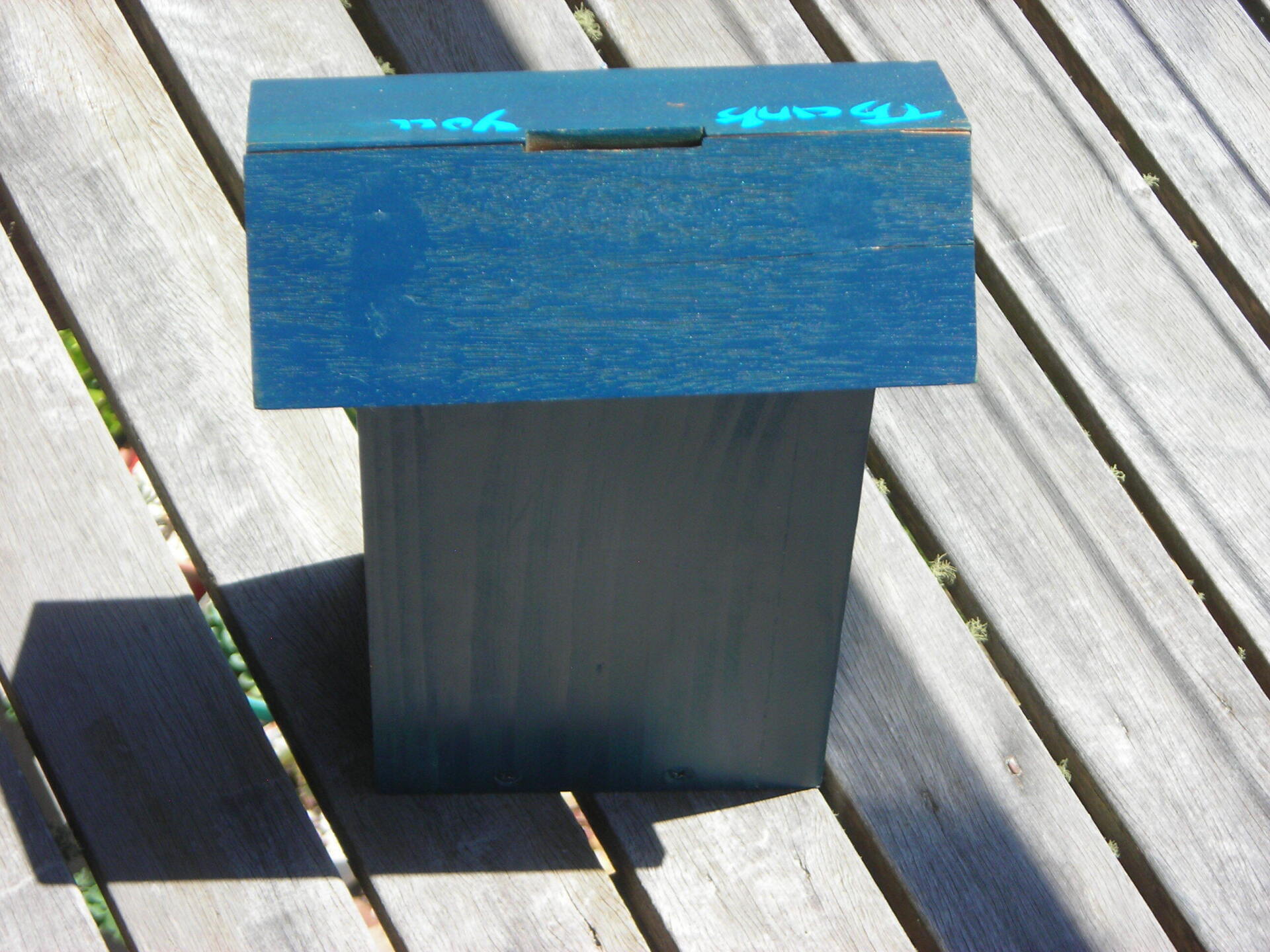 Blue wooden outdoor box on a sunlit wooden deck