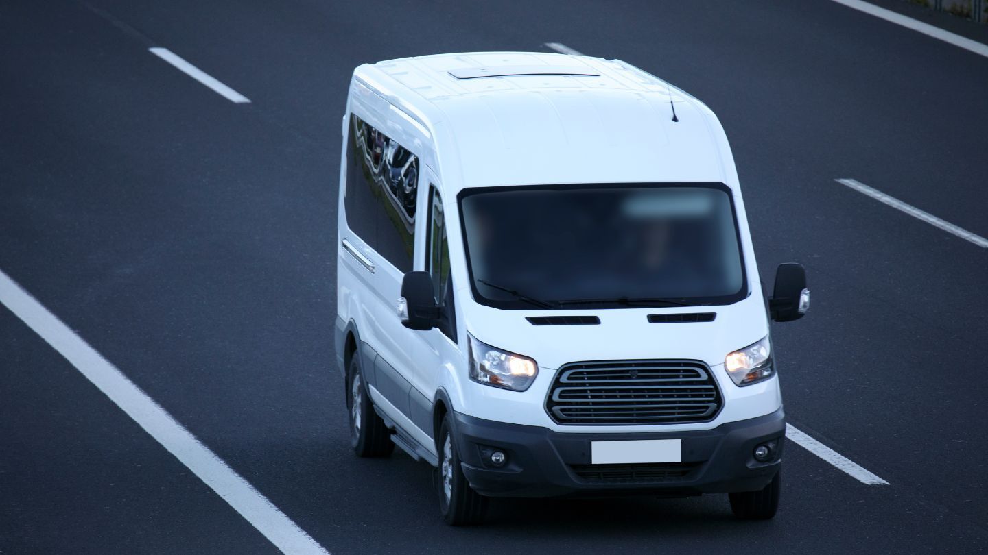 A white van with dark windows, on the road