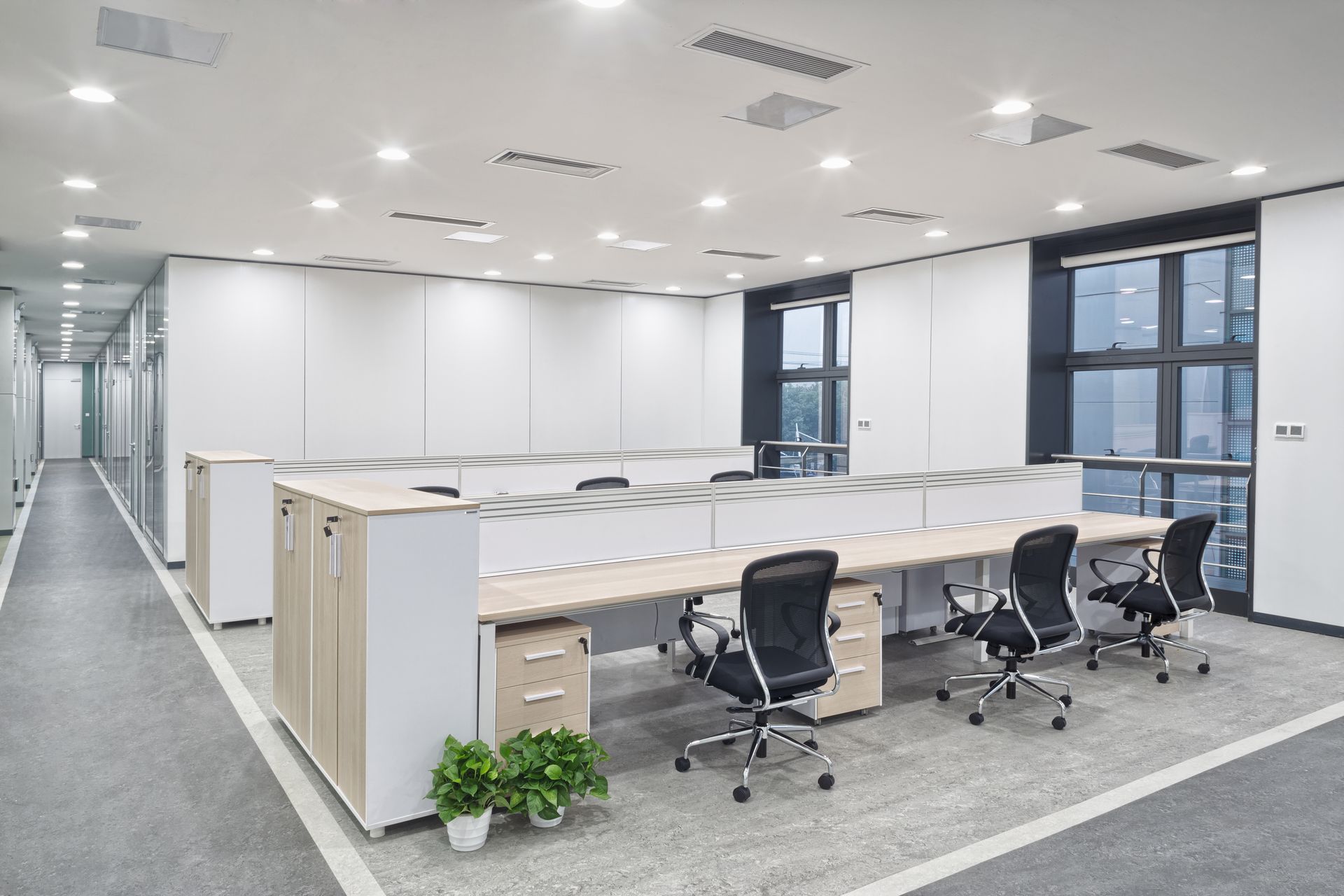 Open-plan office with mesh task chairs, workstations, and storage cabinets