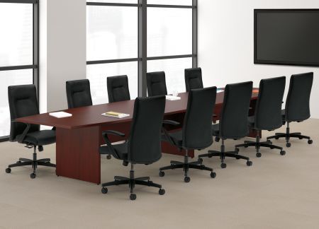 Conference room with a large wooden table, black chairs, and a large screen.