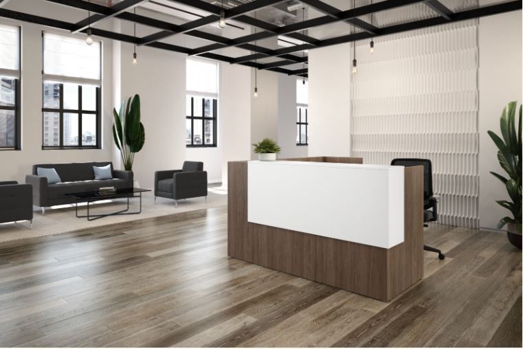 Modern office reception area with wooden floors, white and brown reception desk, and seating.