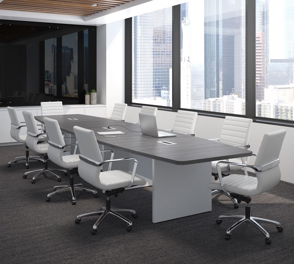 Conference room with a large gray table, white chairs, and cityscape view.
