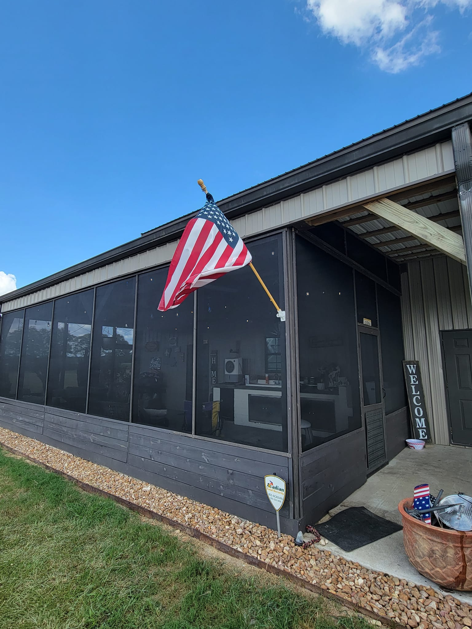 American flag flying outside a screened porch on a sunny day.
