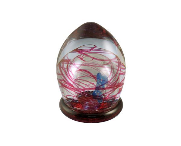 Decorative glass egg with red swirls on a dark wooden stand