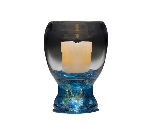 Blue glass candle holder with a white candle inside