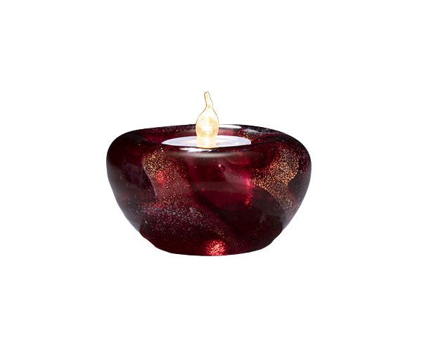 Red glass candle holder with a lit flame on a white background