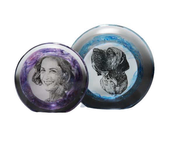Two decorative round discs with sketched portraits, one purple and one blue, side by side