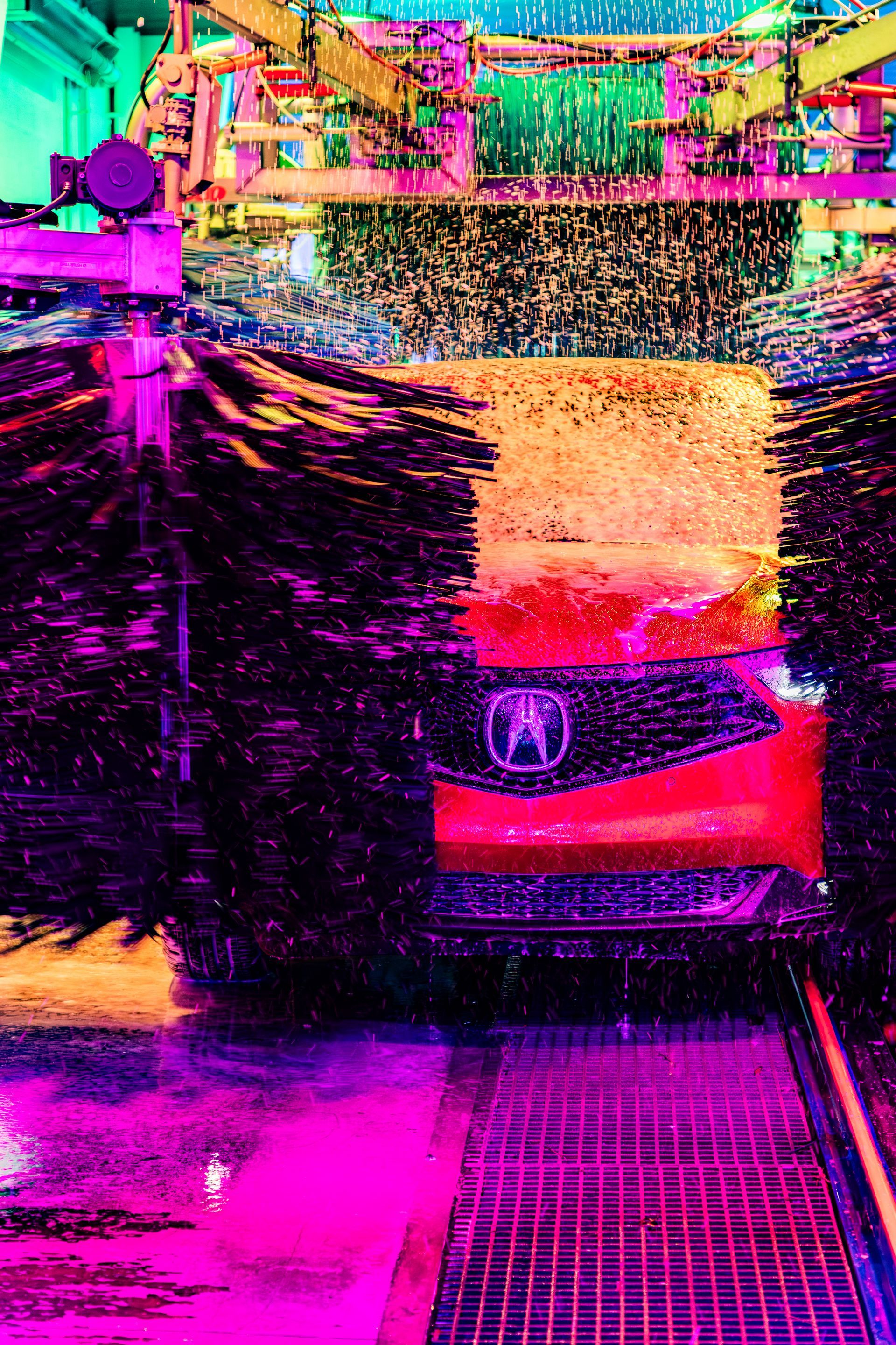 Red Acura car on a wet, reflective street with heavy pink and orange glitch-like distortion