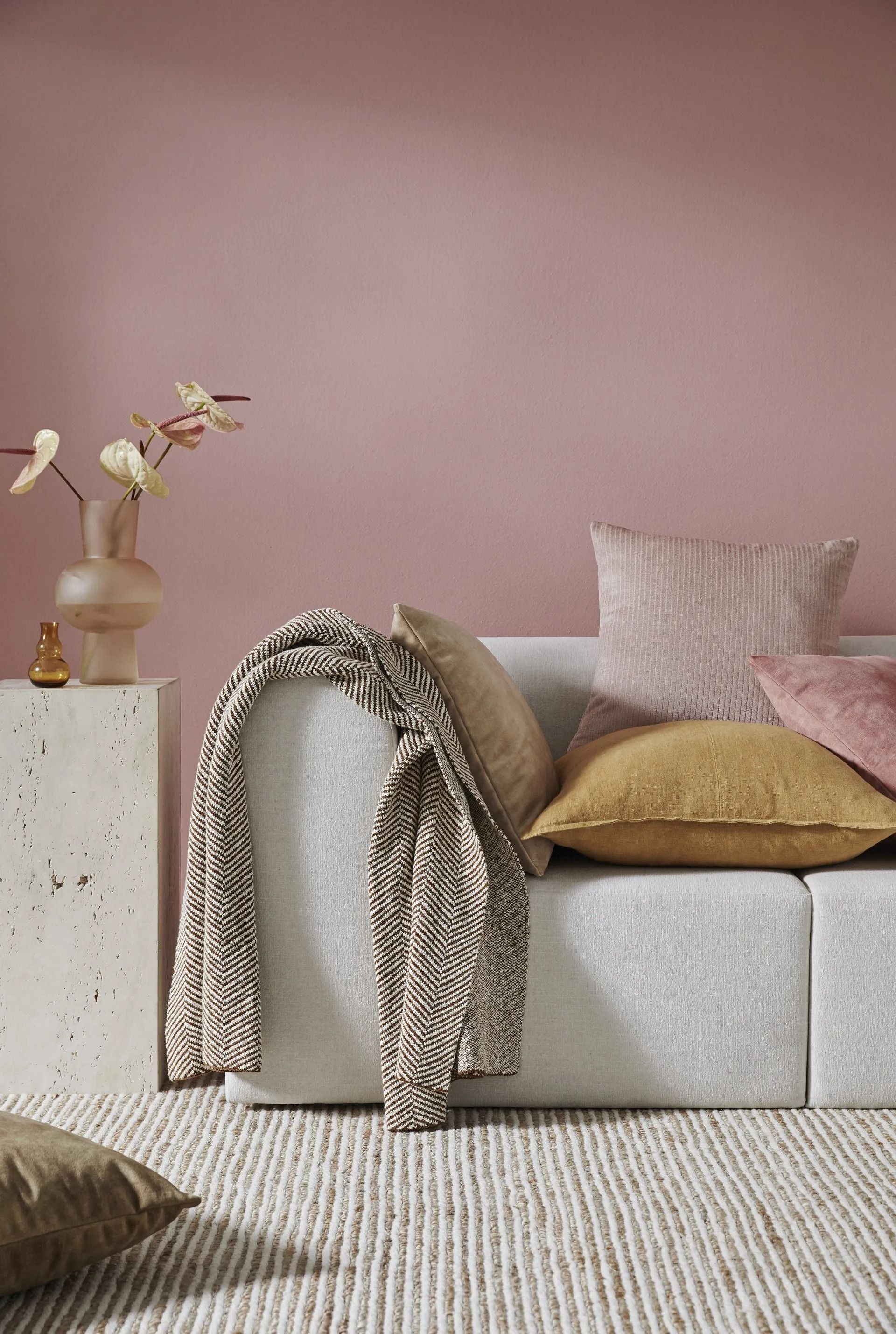 Neutral-toned Living Room With a White Couch, Pink Wall, Rug, Pillows, and Decorative Items — Red Door Decor In Dubbo, NSW