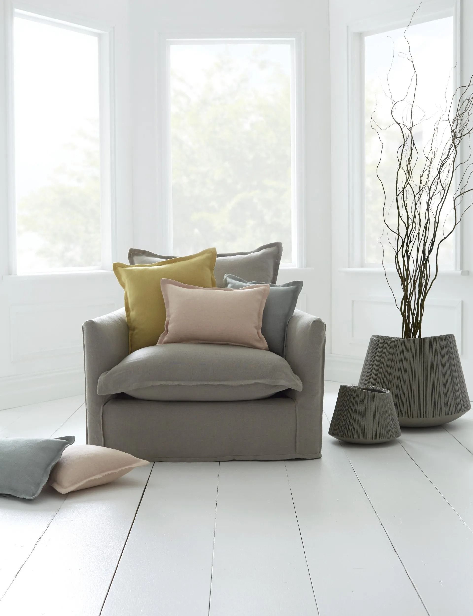Cozy Gray Armchair With Colorful Pillows in a Bright Room — Red Door Decor In Dubbo, NSW