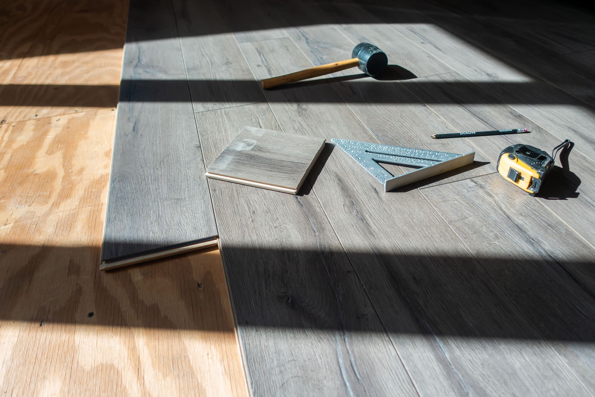 Installing engineered wood flooring with tools on the floor
