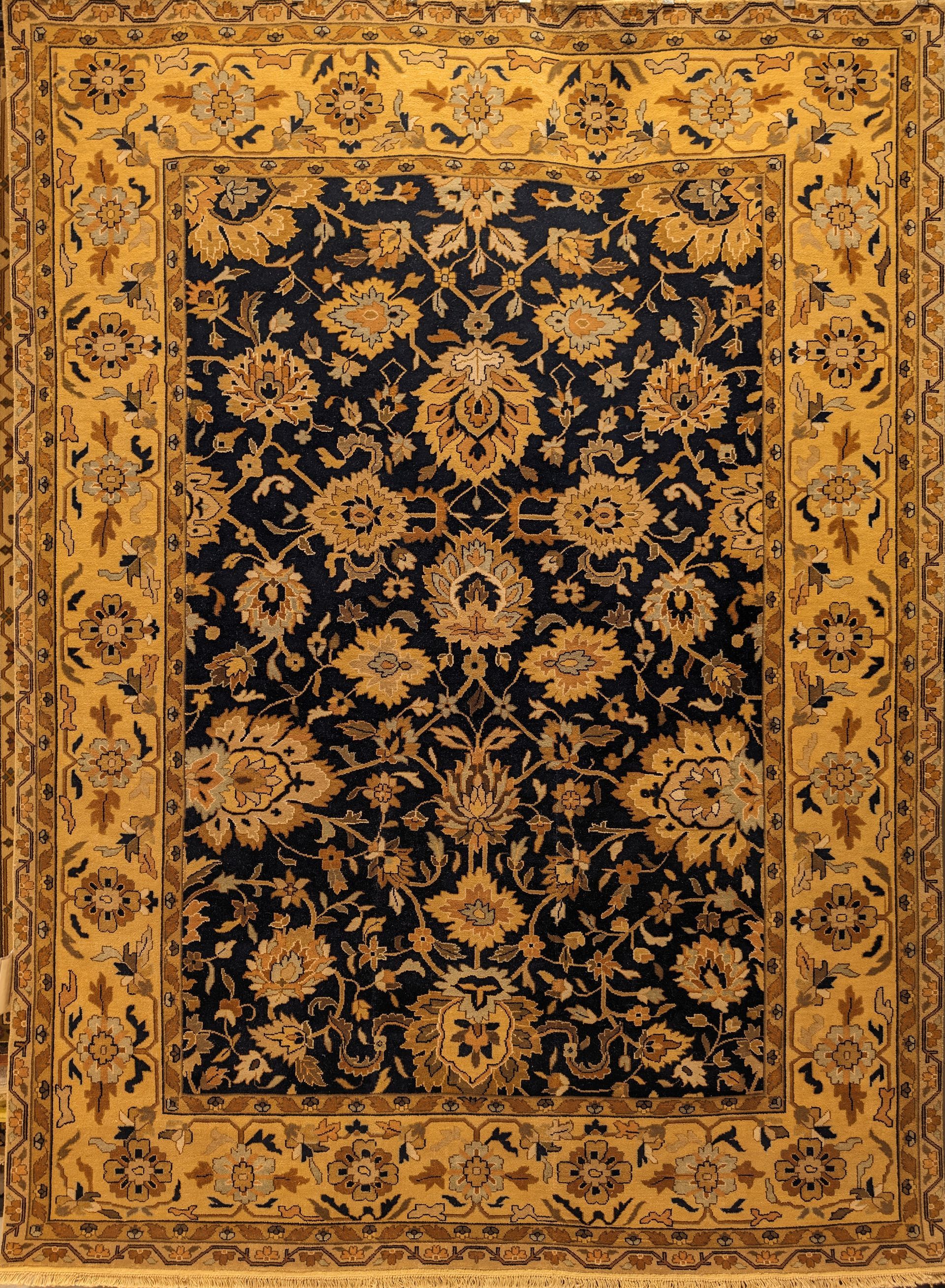 Ornate gold and black floral oriental rug with a dark central field and patterned border