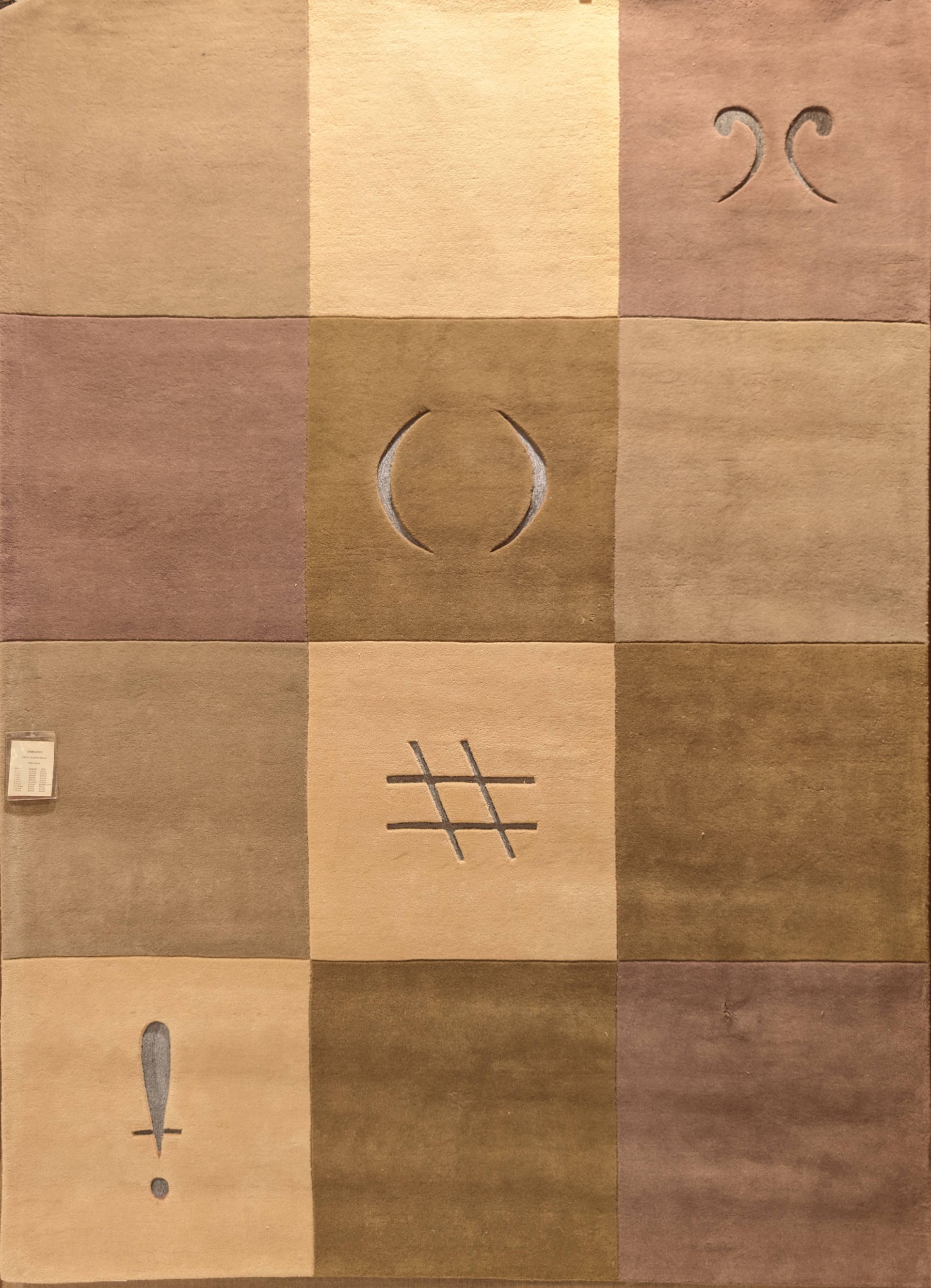 Tan square patchwork with three hand-drawn symbols: curved marks, a circle, a hashtag, and an exclamation point