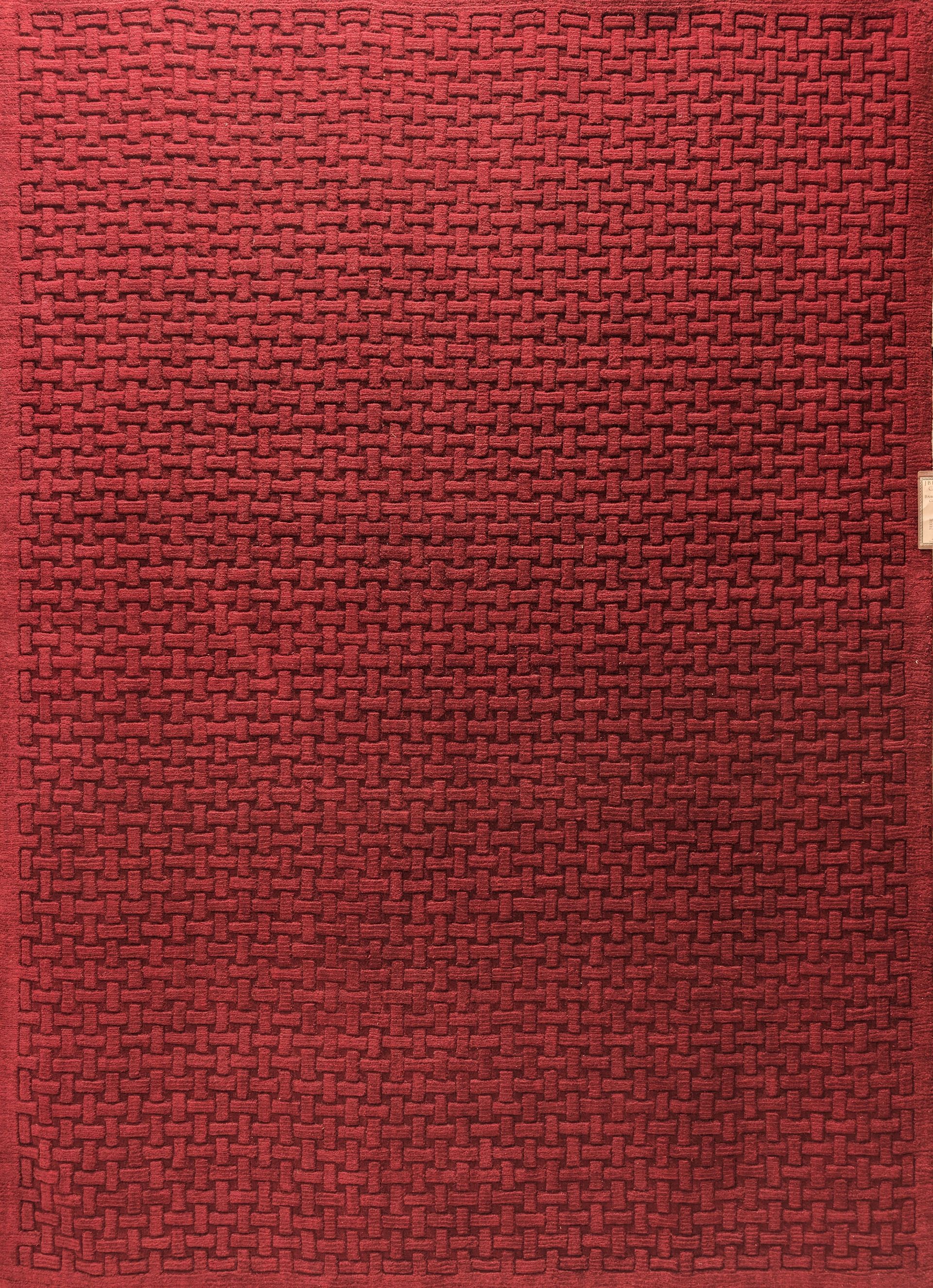 Red woven fabric texture with a small beige tab on the right edge.