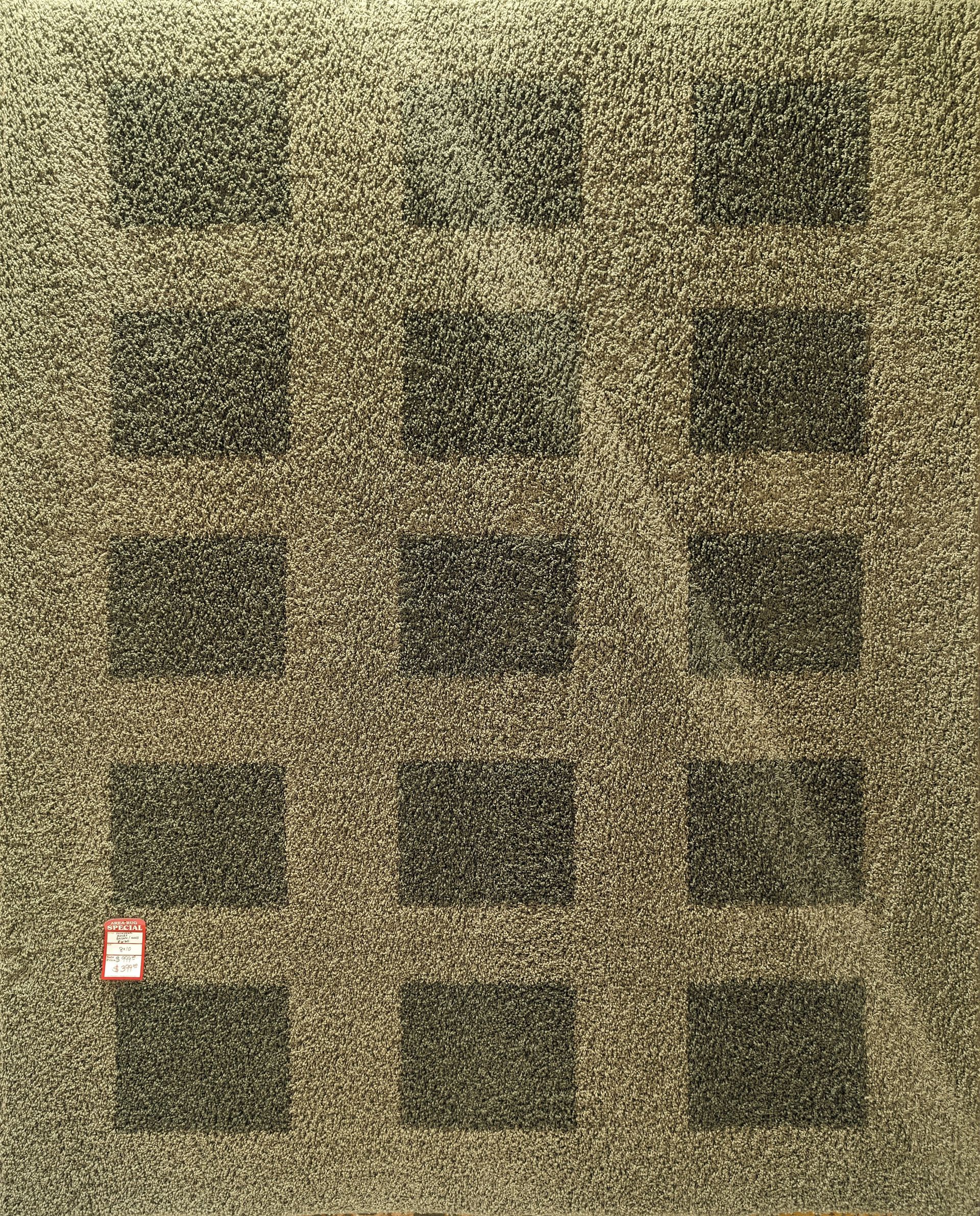 Grid of dark rectangular openings in a stone wall, with a small red sign near the lower left.