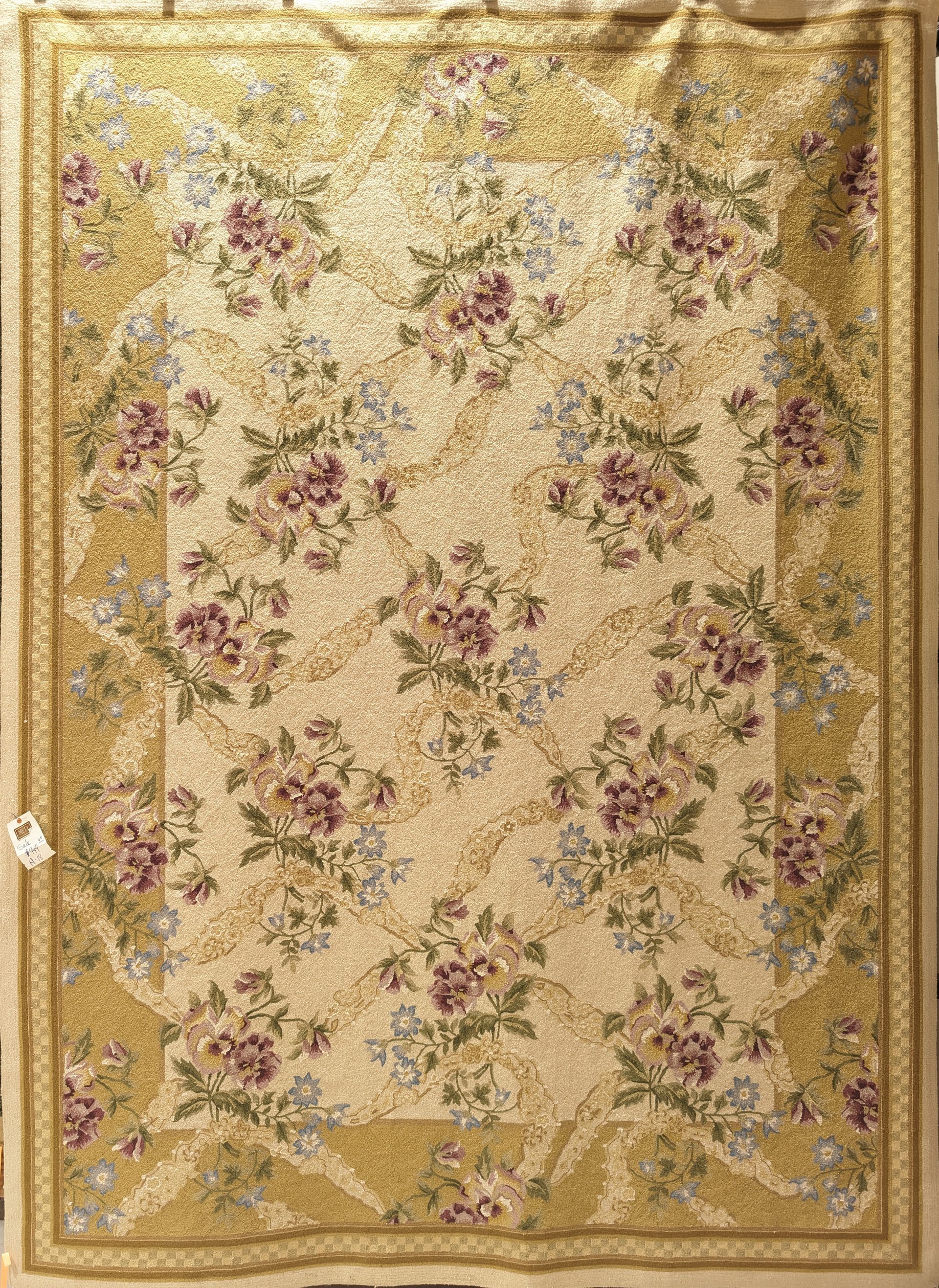 Beige floral patterned rug with gold border and rose accents