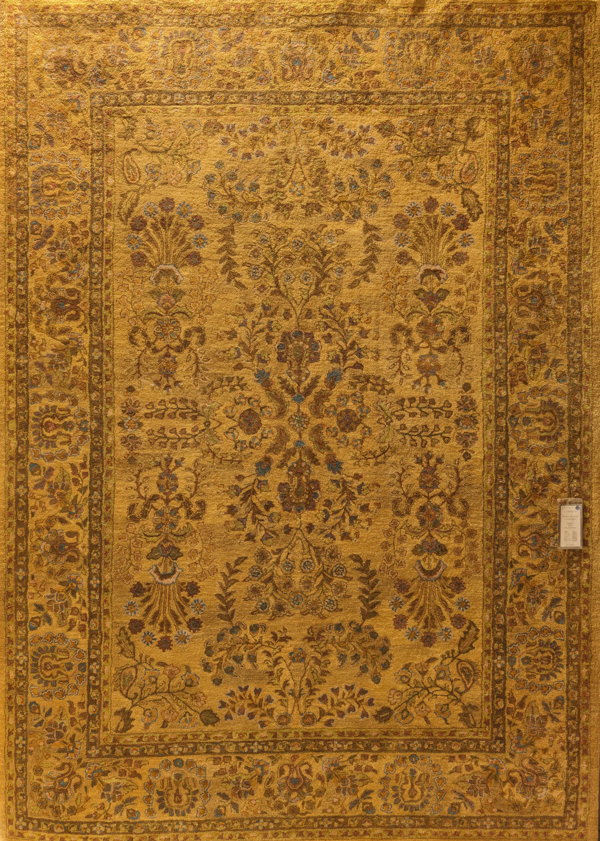 Ornate gold and brown patterned area rug with a decorative border