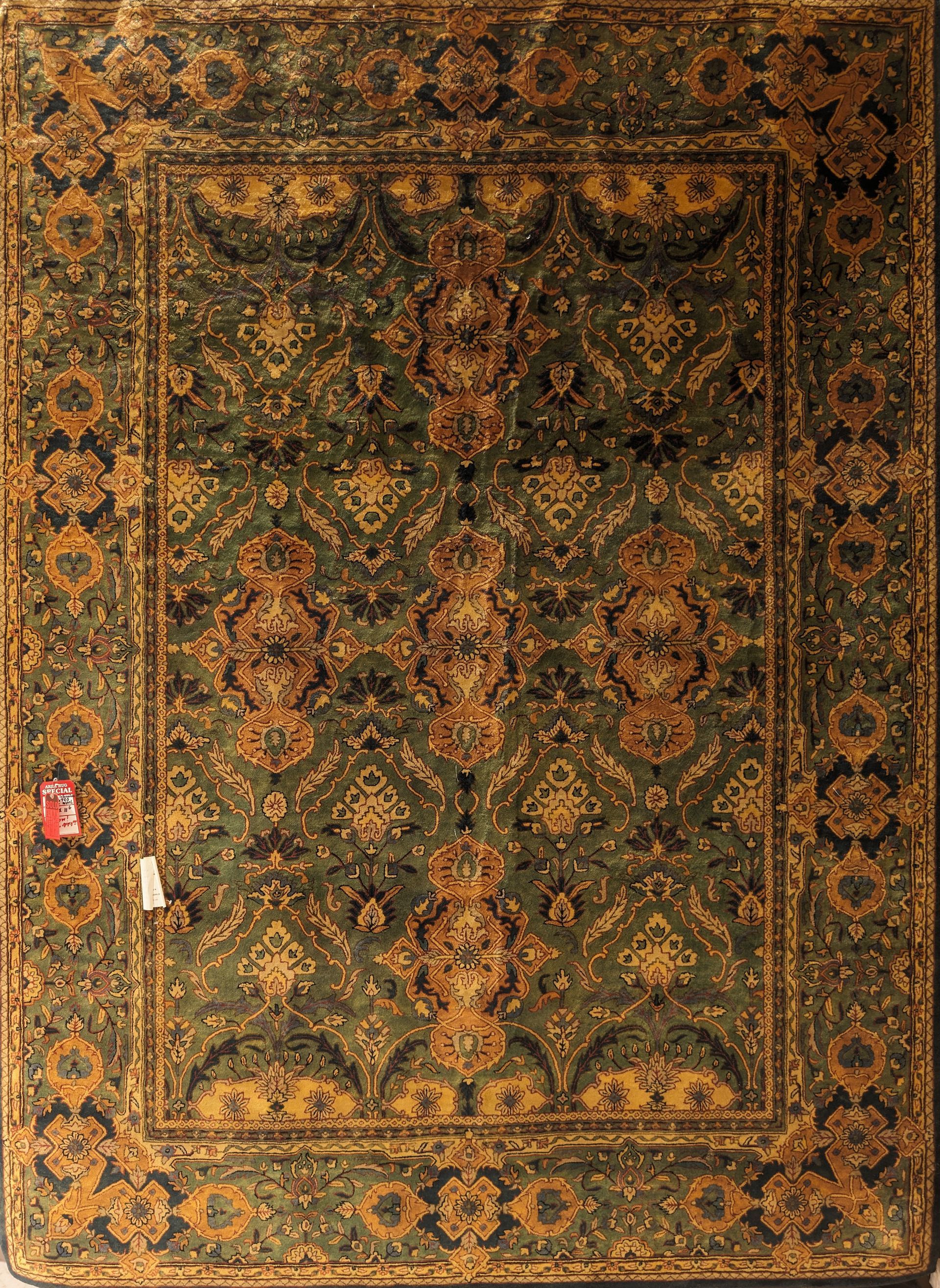 Ornate vintage book cover with dark floral gold and green patterns, worn edges, and a small pink sticker on the left