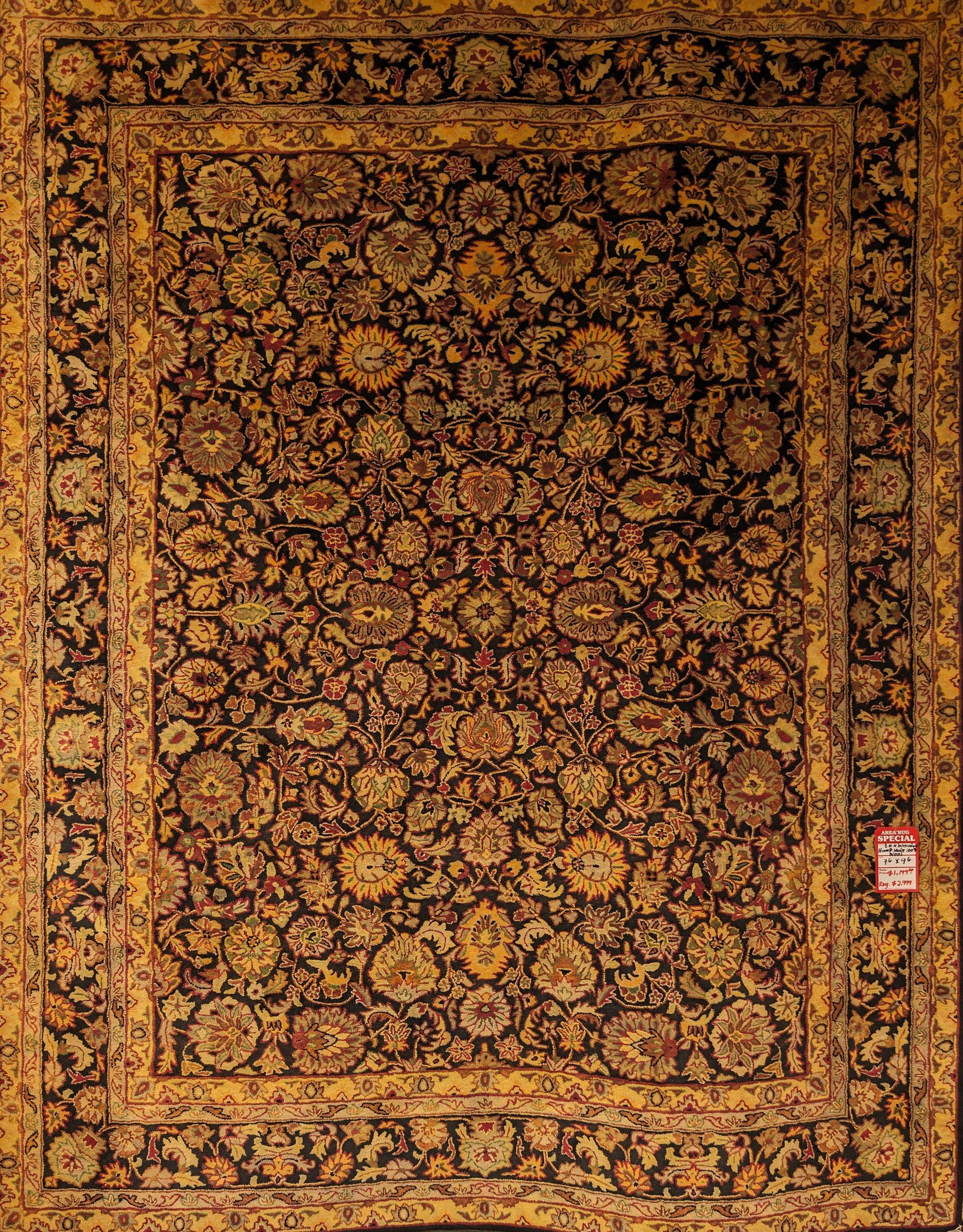 Ornate gold and brown patterned rug with a decorative border and small red label on the right side