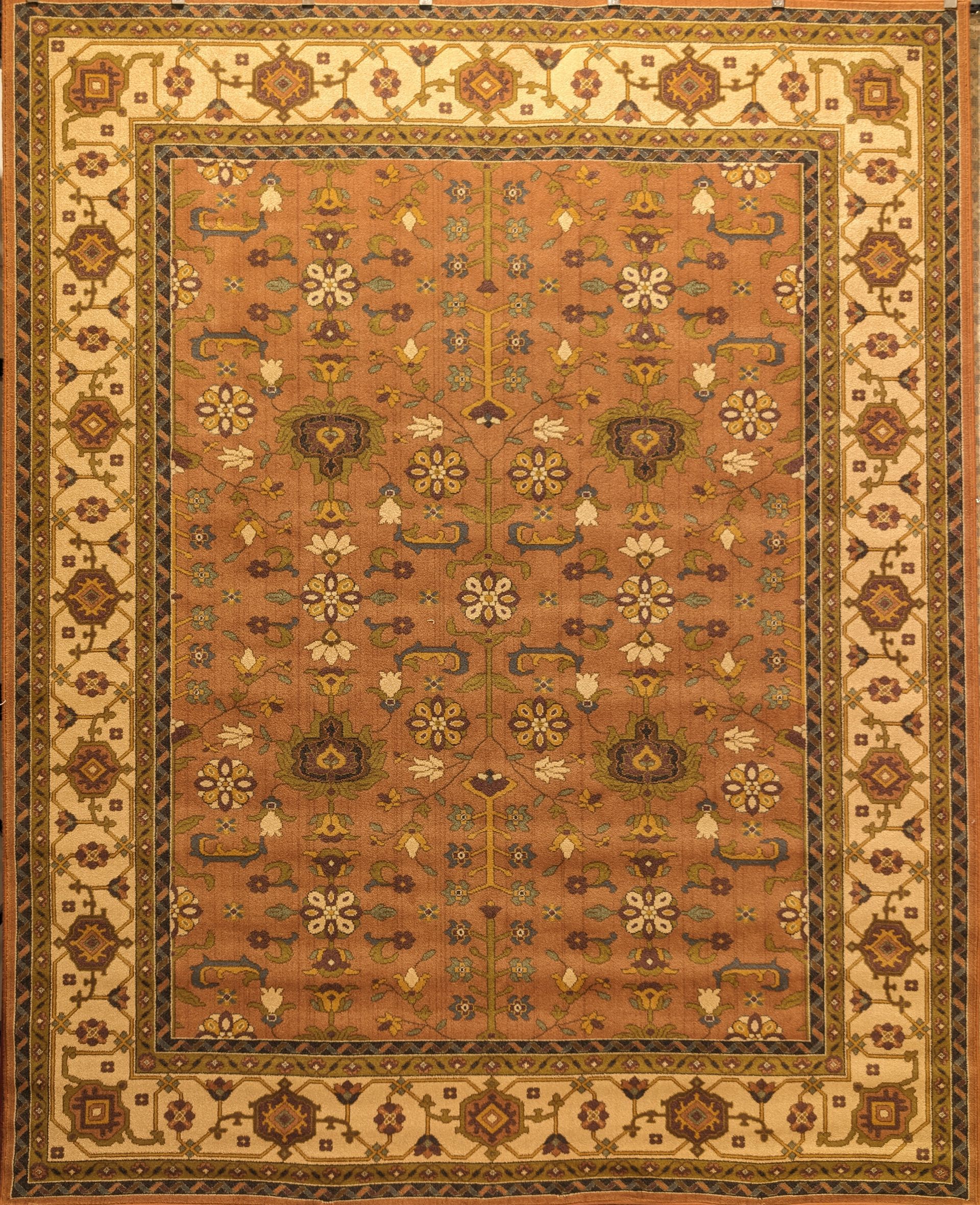 Ornate red and gold patterned area rug with a central floral medallion and decorative border