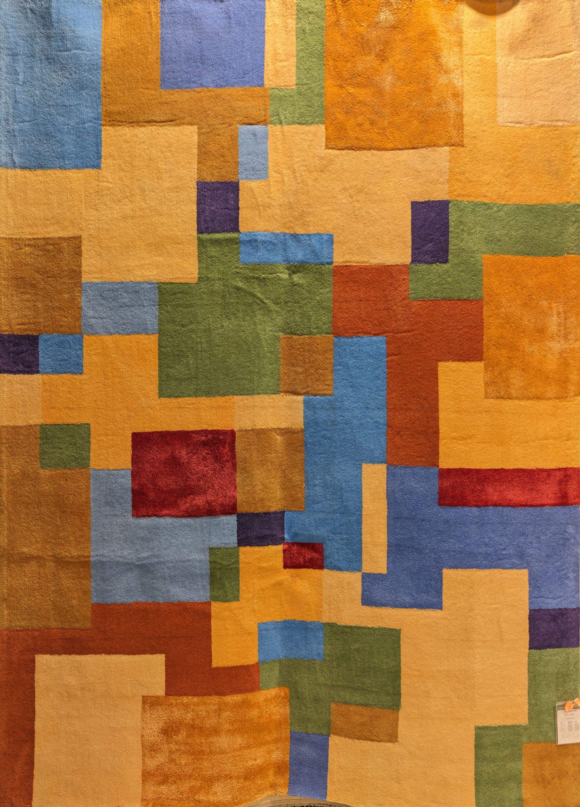 Abstract mosaic of overlapping rectangles in orange, blue, green, red, and yellow tones